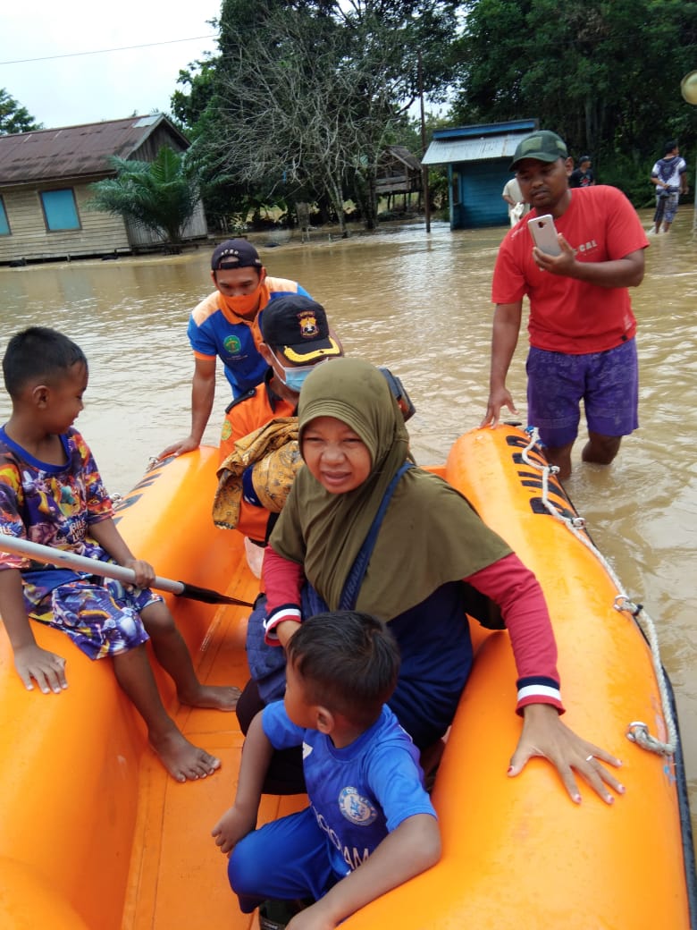 Petugas BPBD saat mengevakuasi seorang ibu