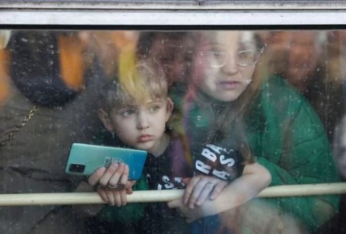 Seorang warga beserta anaknya menatap keluar