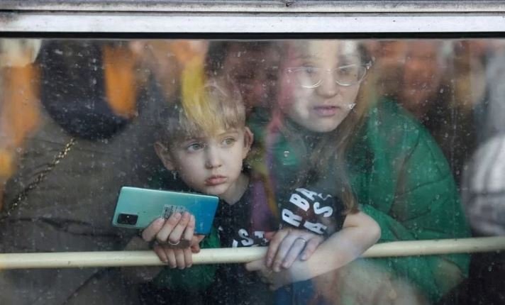 Seorang warga beserta anaknya menatap keluar