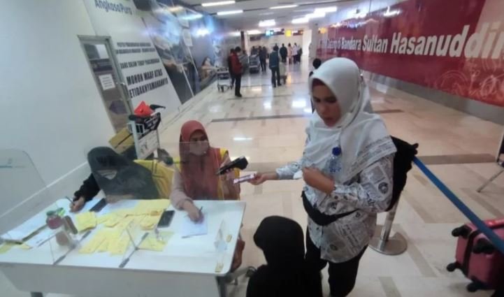 Seorang penumpang menunjukkan aplikasi Peduli Lindungi