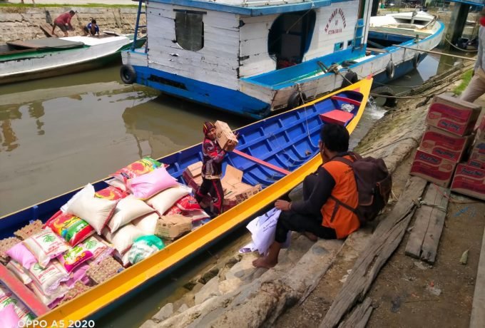 PENYALURAN : Petugas Badan Penanggulangan Bencana Daerah (BPBD), saat menyalurkan bantuan logistik ke Kecamatan Sei Manggaris.