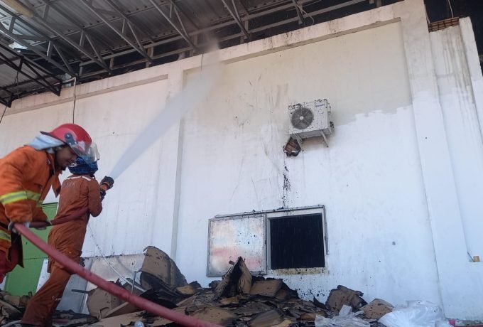 PADAMKAN: Petugas dan warga yang mencoba melakukan pemadaman pada bangunan yang terbakar. (Foto: Okta Balang/Benuanta)