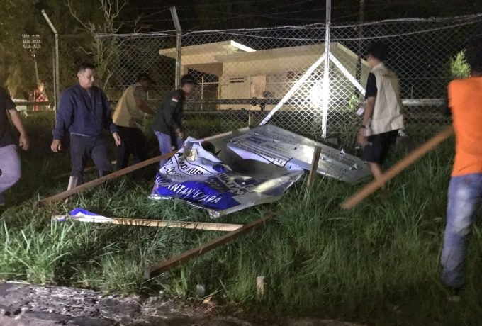 TURUNKAN: Petugas saat menurunkan baliho caleg yang dipasang di pinggir jalan pada Senin, 9 Oktober 2023, malam tadi. (Foto: Endah Agustina/Benuanta)